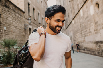 Traveler male discover a big europe city, travel and active lifestyle concept.Bearded Tourist Man with black leather bag enjoy beautiful city travel