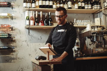 Barista working at the bar with tablet PC