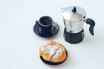 Brewed cake, coffee and coffee maker on the table.
