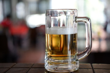 glass of beer on wooden table in a cafe