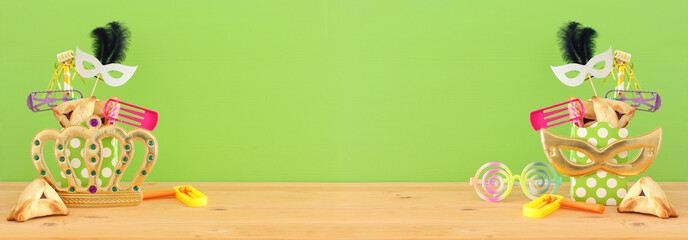 Fototapeta premium Purim celebration concept (jewish carnival holiday) over wooden table and green background.