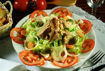 Plato de ensalada con, tomate, lechuga, cebolla,aceitunas, atún y anchoas.