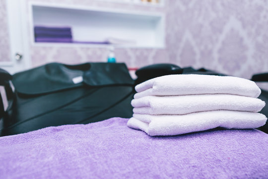 Turquoise Spa Towels Pile On Armchairs With Washing Stands In Hairdressing Salon.