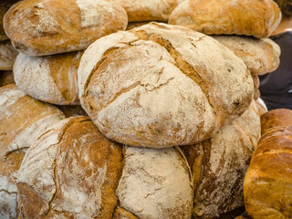 Homemade bread loaves. Fresh bread in bakery background and texture for banner image on website or print media design. Rye bread on market stall. 