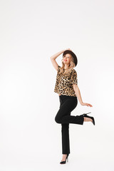 Happy excited young woman with hat isolated over white wall background.