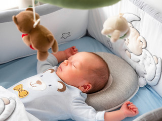 Close-up portrait cute little mixed race Asian and Caucasian baby son sleeping on back. Daytime...