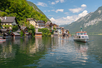 Tourists lake cruise boat on Hallstattersee by the World Heritage lakeside town in the Alps,...