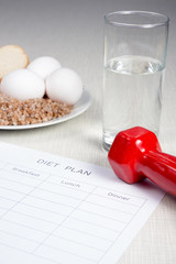 Diet plan with buckwheat,bread,eggs and dumbbell