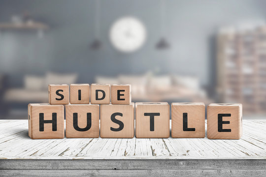 Side hustle sign on a plank table