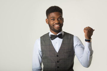stylish african man in a waistcoat on a white background with a hand gesture