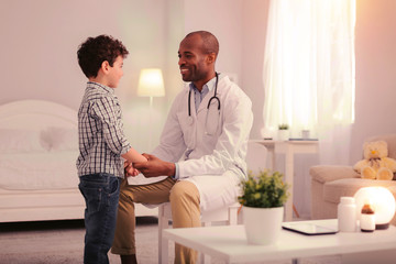 Obraz premium Smiling doctor calming child and preparing child for examination