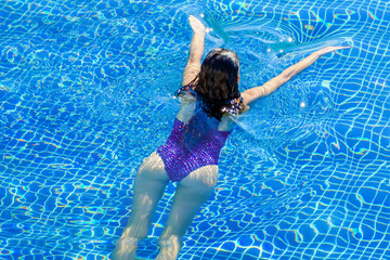 Top view of woman swimming in a pool. Straight body, slim woman. Swim and fitness concept.