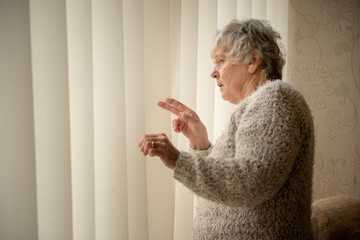 Nosey neighbour, senior woman looking through window