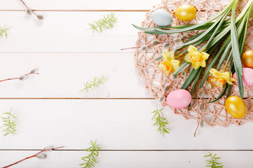 Easter background with Easter eggs and spring flowers. Top view with copy space