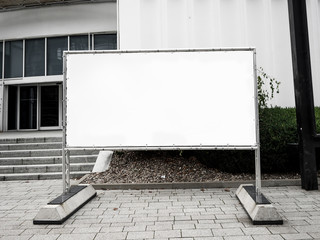 Signboard side view of empty white mock up signage in black frame with exhibition hall wall background display exterior.