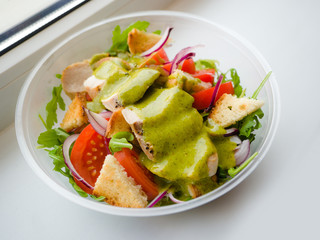 Healthy simple Chicken salad with tomatoes, arugula, green salad dressing and bread croutons in the a glass bowl, Vinaigrette For Green Salad Recipe.