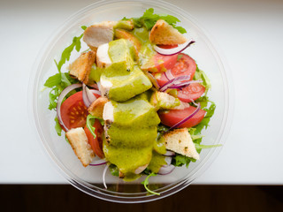 Healthy simple Chicken salad with tomatoes, arugula, green salad dressing and bread croutons in the a glass bowl, Vinaigrette For Green Salad Recipe.