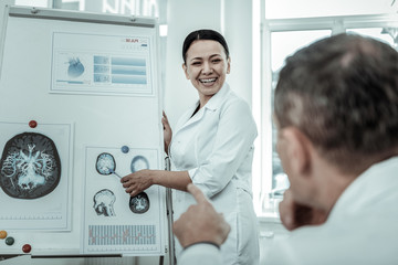 Smiling female doctor showing x-ray photo of brain