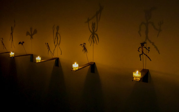 Gruseliges Schattenspiel wirft Geister und D&auml;monen an die Wand mit Kerzenlicht