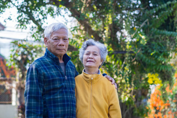 Portrait of romantic elderly man with his wife at home garden.