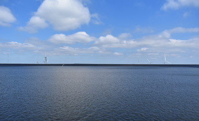 Fototapeta premium Alternative Energy Concept, Wind Turbines on Divided Sky and Dam image