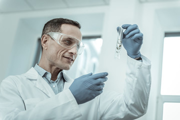 Smiling laboratory worker being interested in plants