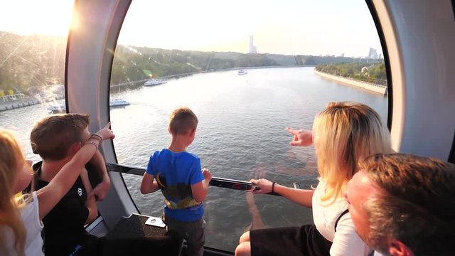 Family with children in cable way in vacation enjoying view