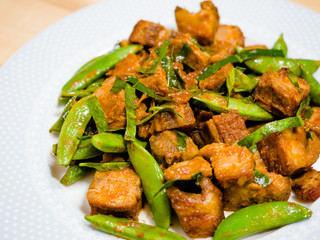 Thai style homemade Stir-fried crispy pork with red chili paste and Kaffir lime leaf with green pea.