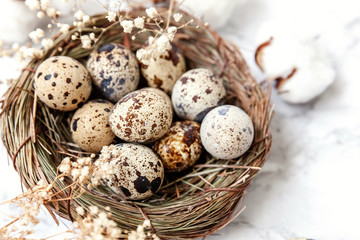 Easter decoration with egg in nest and cotton on white marble background. Easter concept. Flat lay top view copy space. Spring greeting card