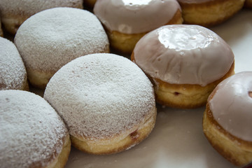 Donuts with icing and powdered sugar on a counter