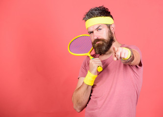 Concentrated on tennis court. Athlete hipster hold tennis racket in hand red background. Tennis sport and entertainment. Man bearded hipster wear sport outfit. Tennis player beginner retro fashion