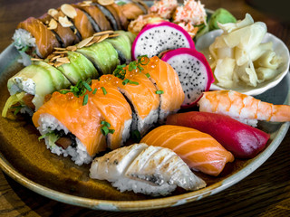 Sushi Set sashimi and sushi rolls served on plate, Rainbow Sushi Roll with salmon, eel, tuna, avocado, royal prawn, cream cheese Philadelphia. Sushi menu. Japanese food.