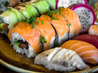 Sushi Set sashimi and sushi rolls served on plate, Rainbow Sushi Roll with salmon, eel, tuna, avocado, royal prawn, cream cheese Philadelphia. Sushi menu. Japanese food.