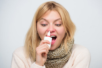 For cold relief. Unhealthy girl with runny nose using nasal spray. Sick woman spraying medication...