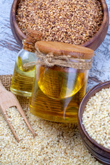 Bottle of sesame oil and sesame seeds isolated