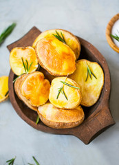 Roasted potatoes with rosemary in wooden bowl