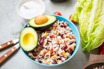 Healthy rice salad with vegetables and avocado, fresh organic vegan salad with fresh ingredients, healthy vegan meal