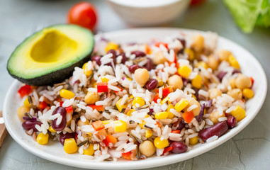 Healthy rice salad with vegetables and avocado, fresh organic vegan salad with fresh ingredients, healthy vegan meal