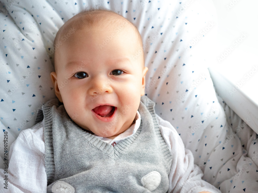 Wall mural cute 4 months old mixed half race asian caucasian boy looking happy smiling and laughing at the came