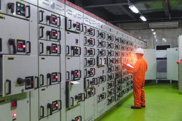 Soft focus of Engineer checking and monitoring the electrical system in Electrical switch gear at Low Voltage motor control center cabinet room,Electrical selector ,button switch.