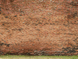 Red brick wall with grass floor
