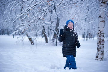 Fototapeta na wymiar a child in a winter Park playing with snow