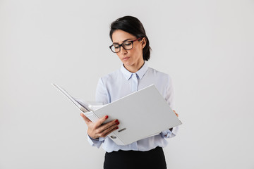 Photo of attractive female worker wearing eyeglasses holding paper folder in the office, isolated...
