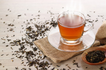 Herbal tea Smoke out Lay on a wooden floor. There are dried tea leaves placed around the glass.