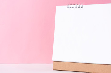 Blank paper spiral calendar for mockup template advertising and branding on pink background.