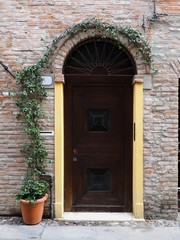 Fototapeta na wymiar Facade. Italian house and wooden door.
