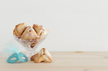 Purim celebration concept (jewish carnival holiday) over wooden table.