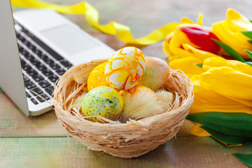 Easter eggs, mockup laptop and bouquet of tulips.