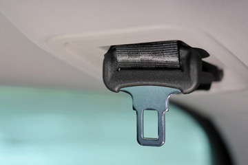 safety belt in the trunk of a car. Element of car seat belt with selective focus on blurred background. Automobile chrome belt buckle and black seat belt. Life safety in a car. Fasten the belts for pe