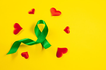 Liver Cancer and Hepatitis B - HVB Awareness month ribbon, Emerald Green or Jade ribbon awareness color on yellow background. The cancer, health, help, care, support, hope, illness, survivor